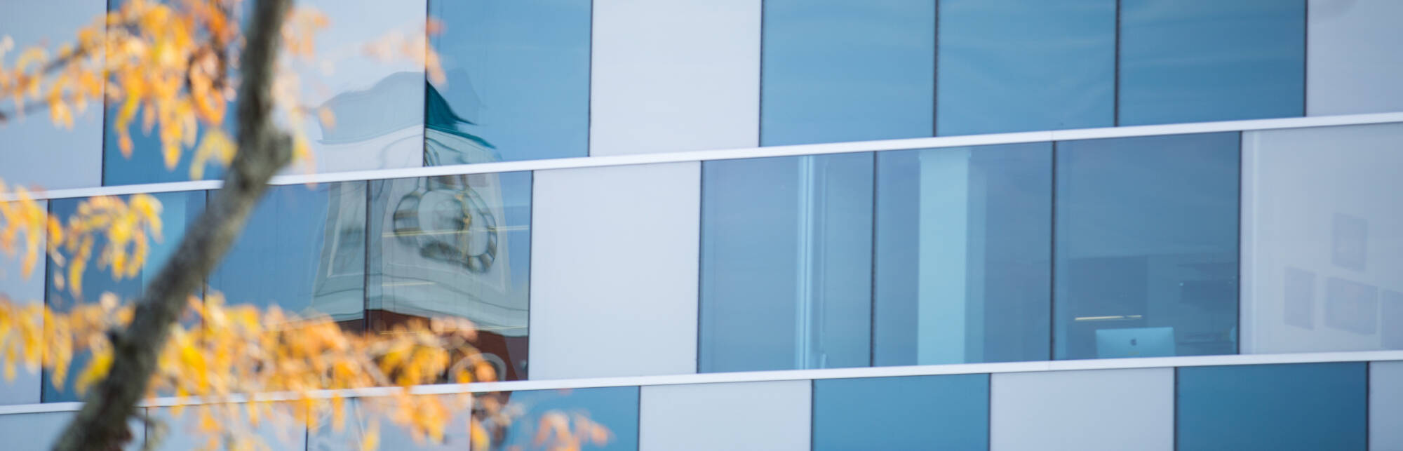 carillon tower seen in reflection of windows of Zumberge Hall